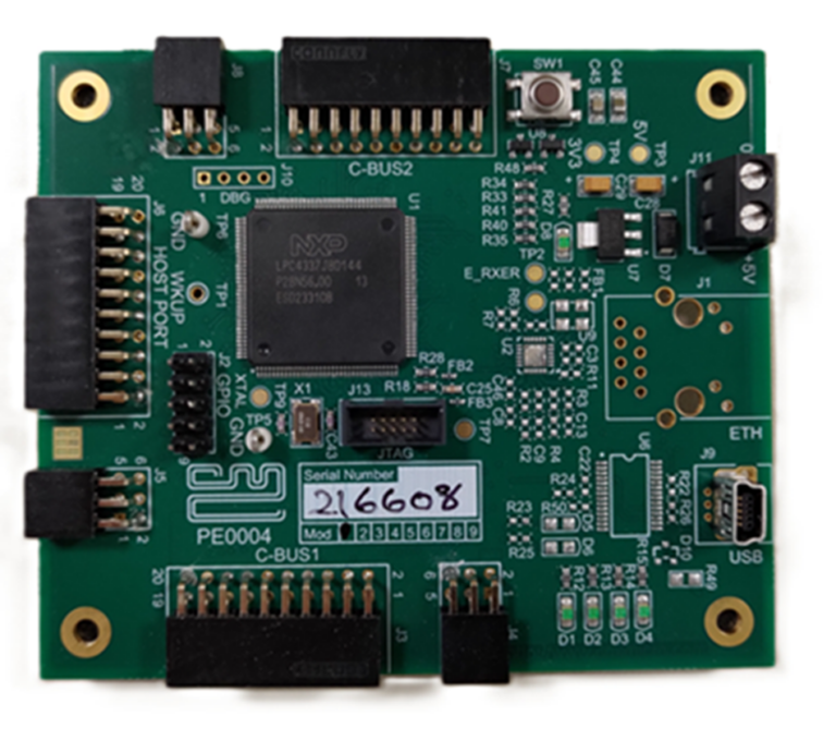Photograph of the PE0004 development board with an NXP LPC4337 microcontroller, C-BUS1/C-BUS2, host port, JTAG, Ethernet and USB connectors